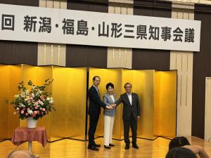 手を合わせて写真撮影する三県知事